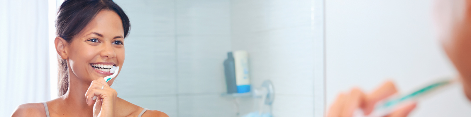 Oral Cancer Prevention | Woman Brushing Teeth in Mirror