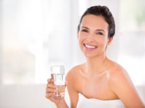 Portrait of a beautiful woman holding a glass of water