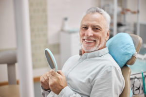Elderly man in dentist's chair without fear waiting for treatment of their teeth