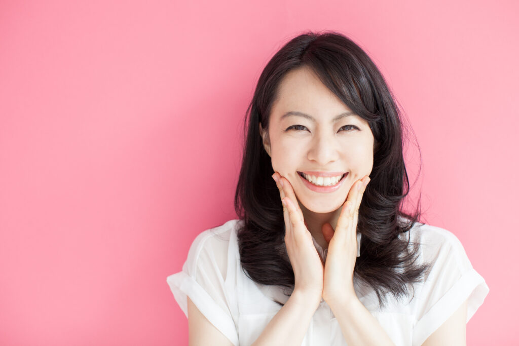 Happy,Young,Woman,Against,Pink,Background